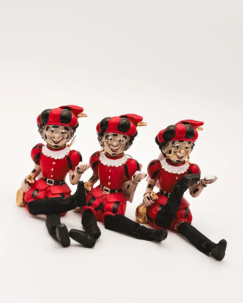 Drie zittende Piet-figuurtjes in rood-zwart pak